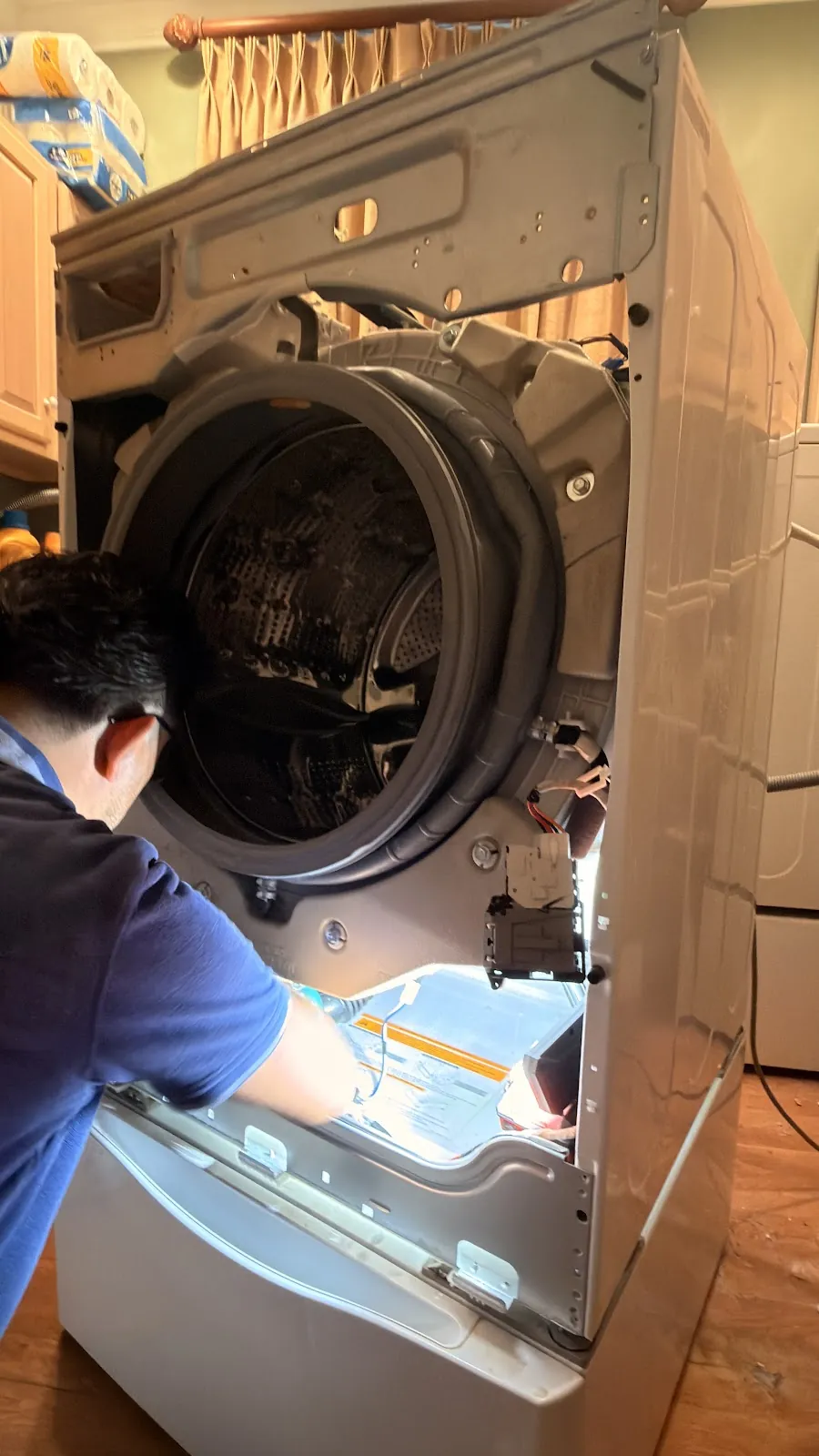 Technician working on an open front-load washer door seal