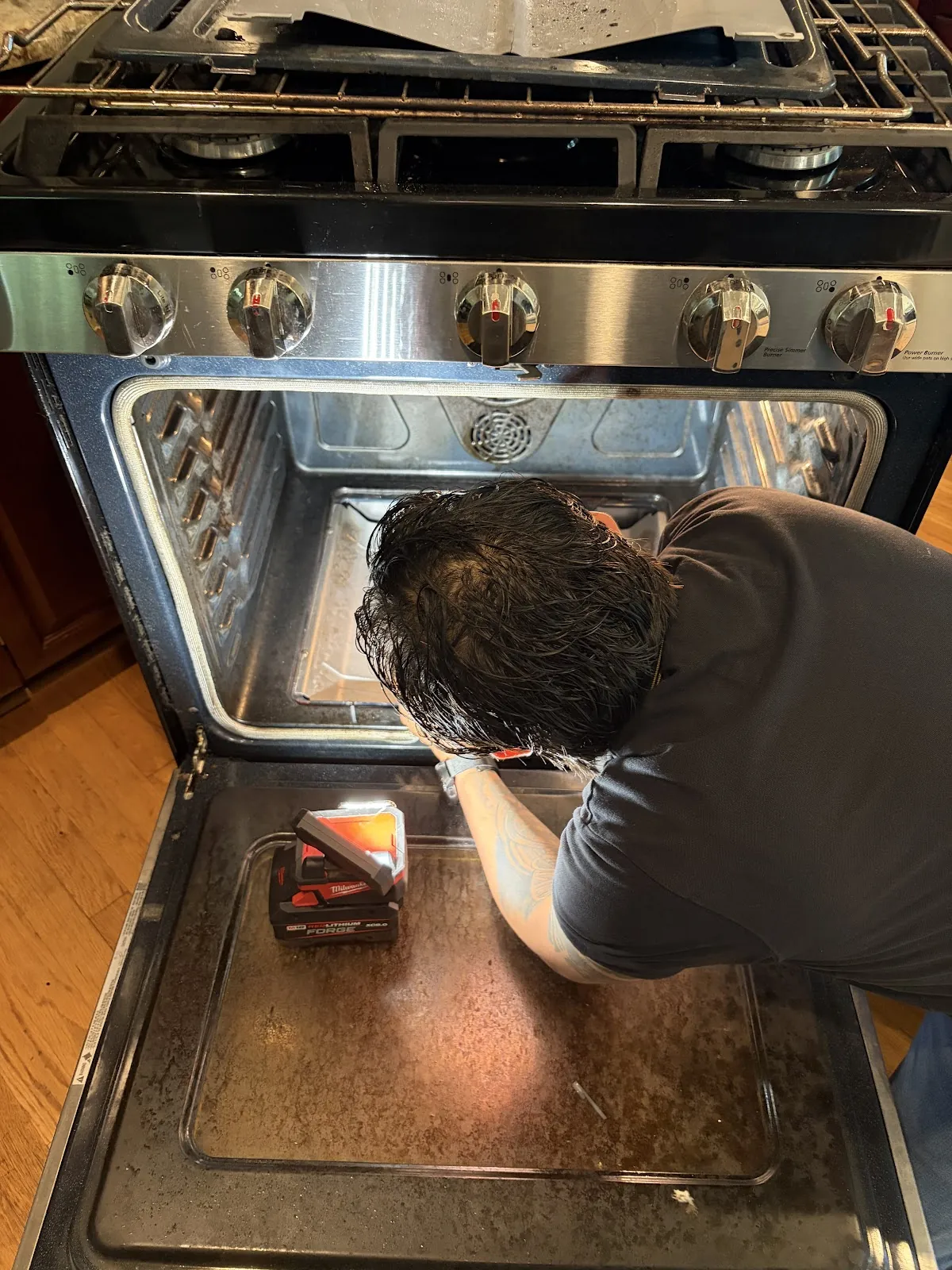 Technician servicing the inside of a wall oven